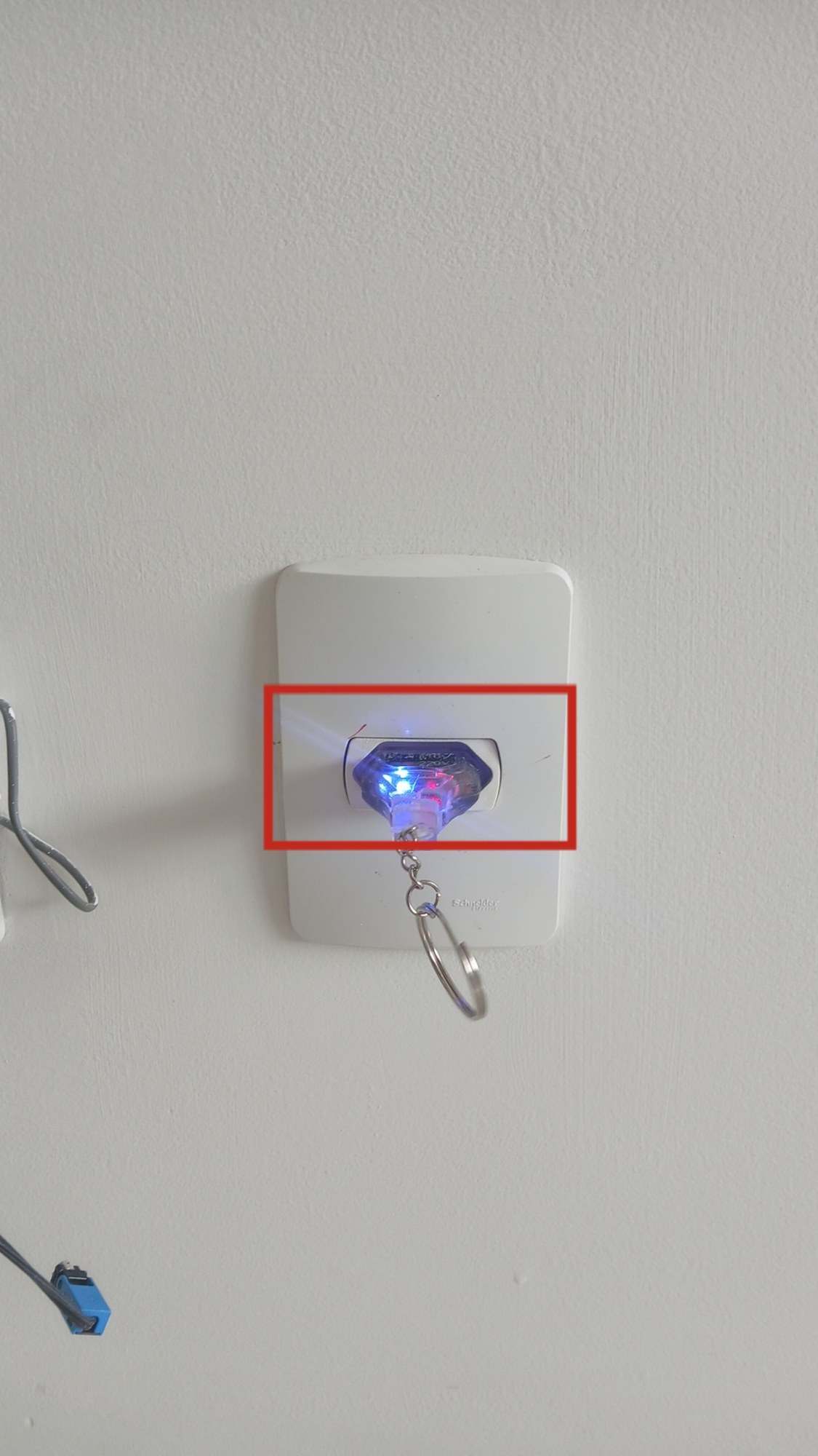 Tomada com testador aceso e marcação vermelha em volta do encaixe com folga.