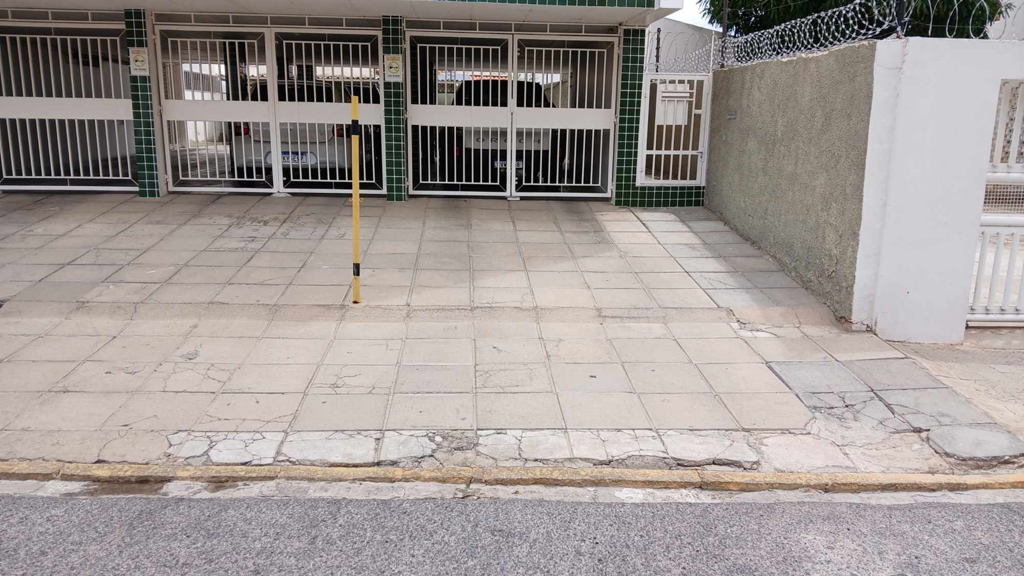 Calçada e portões do imóvel vizinho registrados antes da obra.