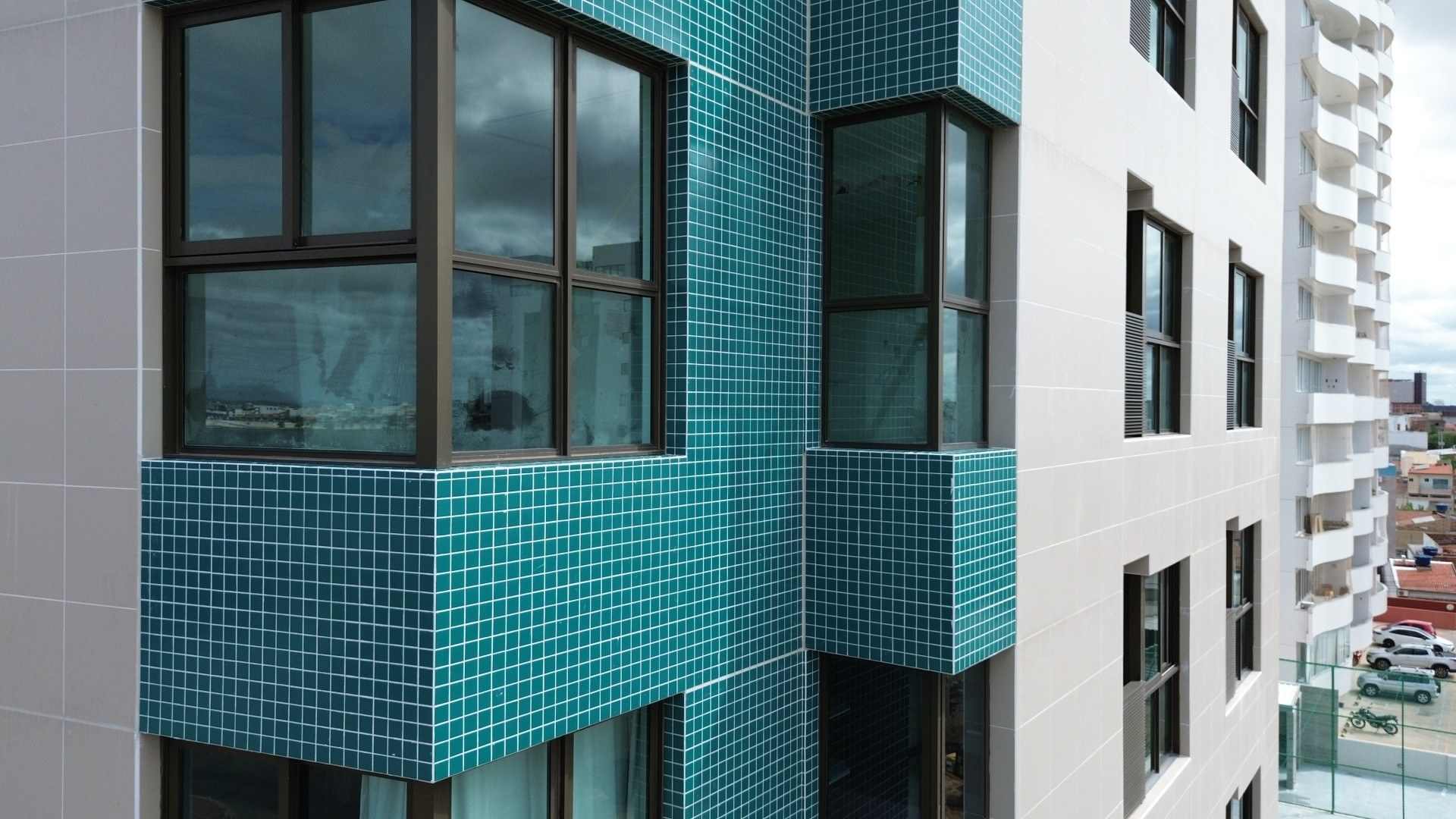 Esquina da fachada do prédio vista do drone, com as janelas e o revestimento.