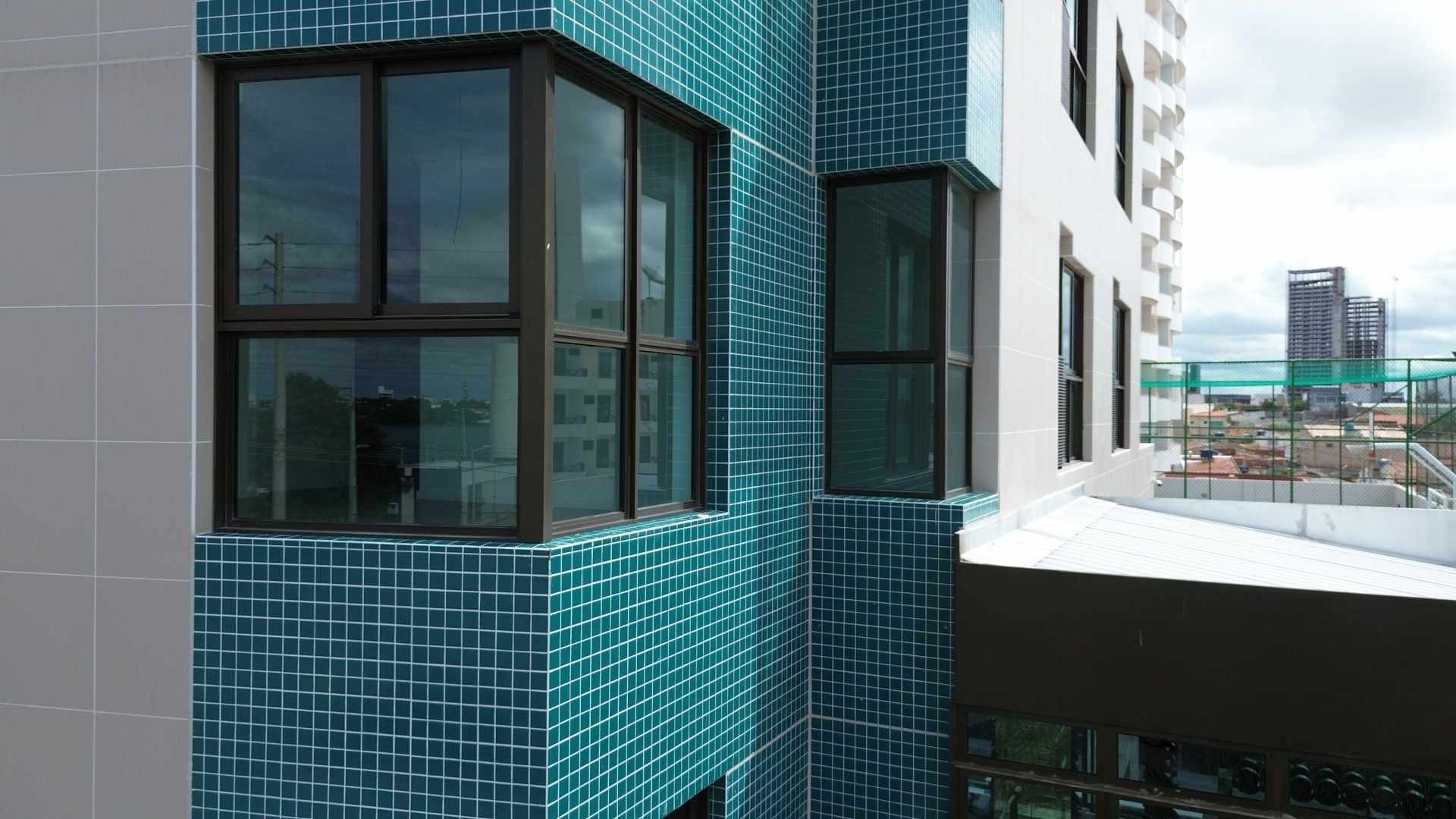 Fachada de prédio vista do drone, na altura de um pavimento, com revestimento em pastilha.